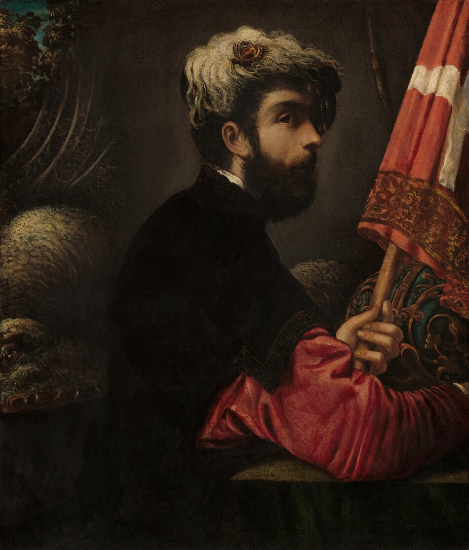 Shown from the waist up, a pale-skinned man sits in front of the coiled body of a dragon in this vertical painting. The man’s body faces our right in profile, but he turns his head to look off to the right out of the corner of the large, dark eye we can see. He has short black hair, a bushy beard, and a small nose. A dark cap is draped with a feathery or fleecy material around a gold-colored medallion, which may show a person. The man wears a short sleeved black tunic over a raspberry-pink, long-sleeved garment. His right arm, closer to us, rests near the corner of a table, and he holds a staff with a partly rolled-up flag with the other. The lower section of a white cross on the red flag is visible, and the bottom edge is trimmed with a bronze-colored, floral motif. A round, peacock-blue object with gold filigree, perhaps a helmet, lies on the table just beyond his hands. The dragon’s lizard-like head lies on the left behind the man’s back. Greenish-brown scales cover its body, and one glassy, open eye and sharp fangs are illuminated by light from above. Its body forms a hump beyond the head before it curls across the back of the painting. The dragon and man are in front of an ash-brown curtain, which sags in the top left corner to show the canopies of trees and a blue sky.
