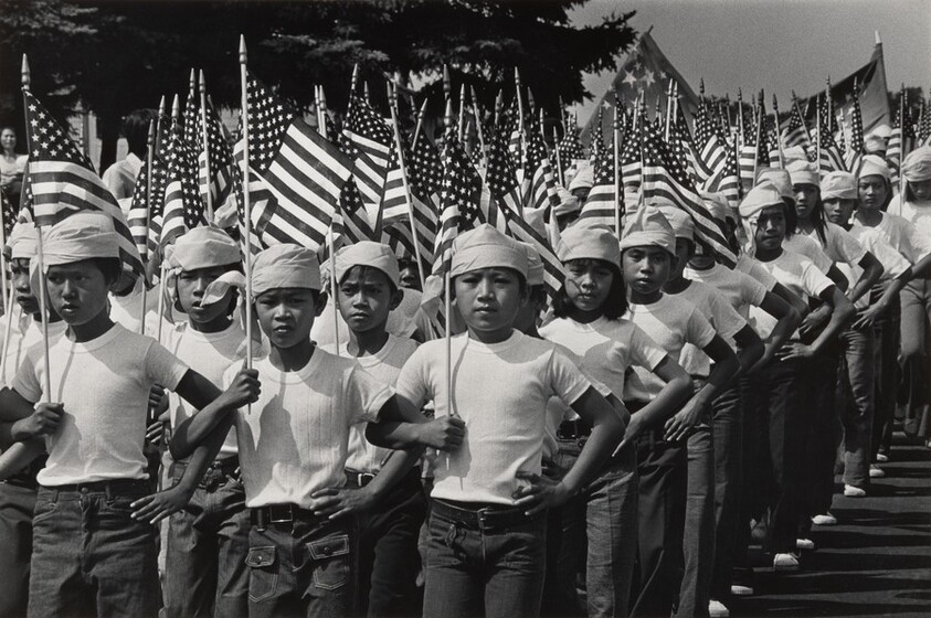 Barely two months after the fall of Saigon, U.N. refugee boys and girls march in a 4th of July parade organized by Americans at Indiantown Gap Refugee Camp, PA