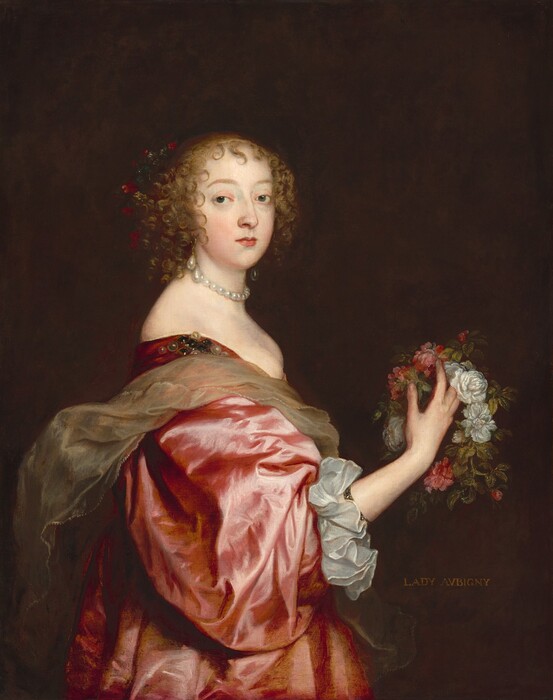 A woman with a pale, peachy skin stands wearing a voluminous rose-pink, silk dress and holding a wreath of pink and white roses and greenery in this vertical portrait painting. Shown from the hips up, her body faces our right in profile, and she turns to look at us from the corners of her dark gray eyes. Her light brown hair is pulled up but curls frame her oval face and pointed chin, and falls in ringlets to the base of her neck. She has gently curved eyebrows, a straight nose, and her small pink lips are closed. There may be some red flowers in her hair, but these are lost in the nearly black background. She wears a short necklace made of large, round pearls and large, teardrop pearl earrings hang from her lobes. Her long pink dress is cut low across her bust and wraps around her shoulders and across her back. A pearl adornment is affixed to her dress at the shoulder we can see. The sleeve of her right arm, closer to us, billows to her forearm, which ends with a wide, white, ruffled cuff. She holds the rose wreath with her right hand up at chest height. A sash of stiff, crinkled, tan, sheer fabric loosely wraps around her chest and back. The inscription “LADY AVBIGNY” is painted in tan lettering against the dark brown background at the woman’s waist level on our right.