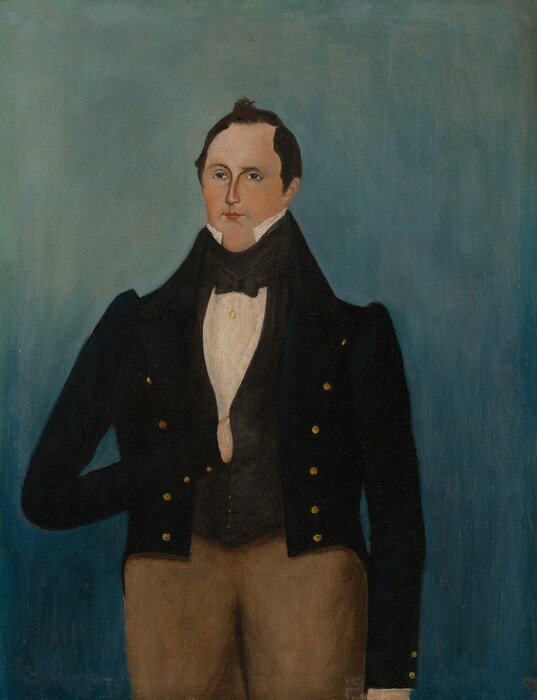 The image shows a man standing in a straight posture. He has fair skin, dark brown hair styled neatly, and a neutral expression. He wears a high-collared white shirt, a dark suit with a black coat, a black waistcoat, and brown trousers. The background is a smooth gradient of light to dark blue.