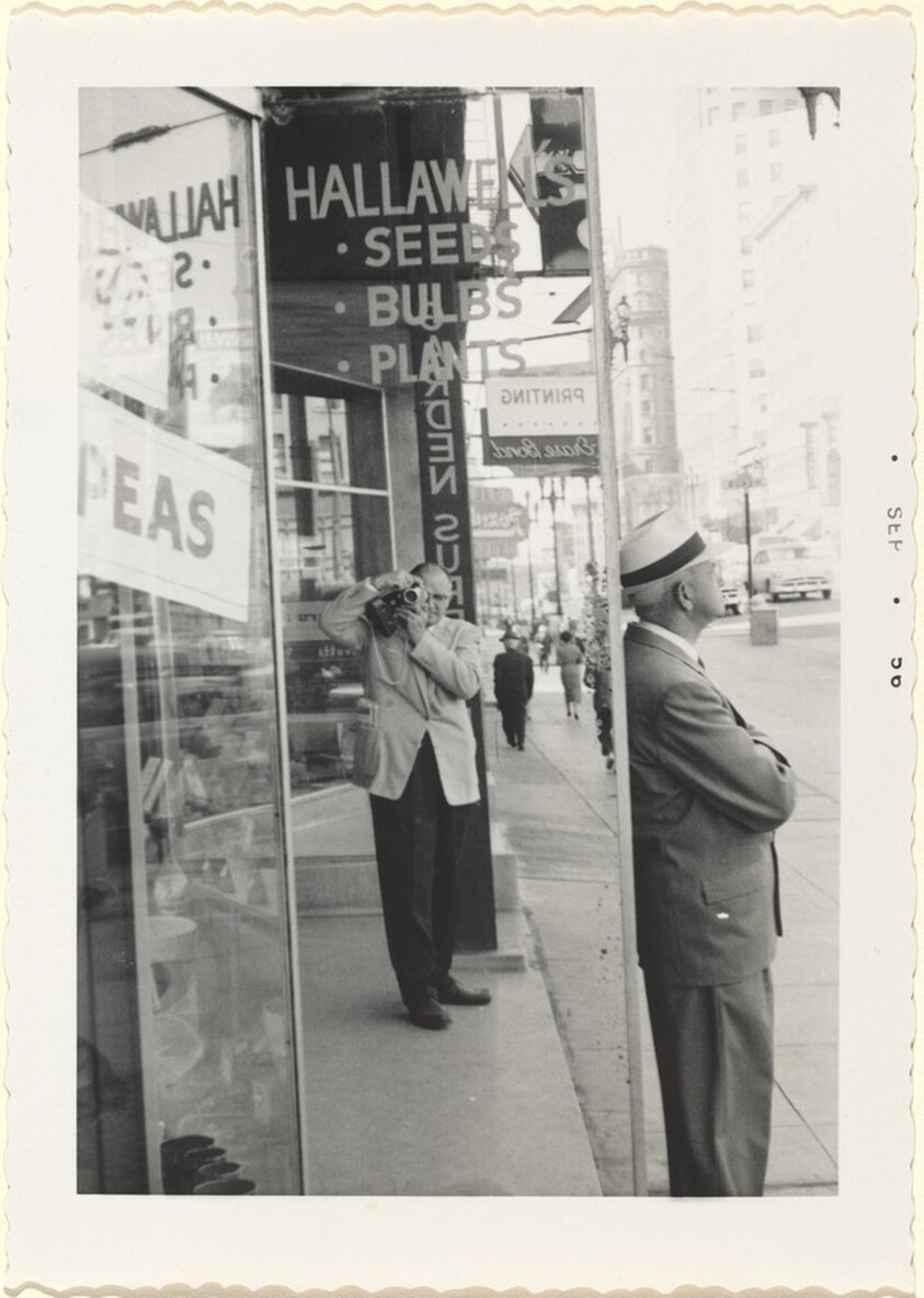 Untitled (Man on street taking pictures of himself in mirror)