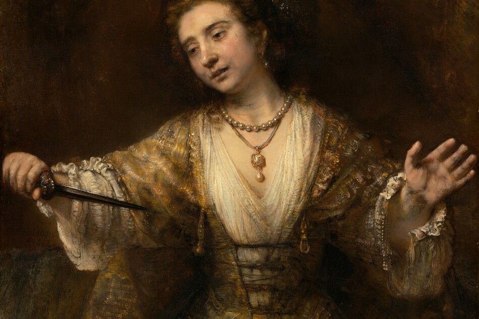 Shown from the thighs up, a pale-skinned woman looks down and off to our left as she holds the pointed end of a dagger toward her chest in this vertical painting. Her lips are slightly parted, and her arms are spread wide as holds the hilt of the dagger in her right hand, to our left. Her hooded, dark brown eyes are rimmed with red. Her head tilts to our left, her pale lips parted. There are gray shadows at the corners of her mouth and along her jawline. Her brown hair is pulled back under a cloth covering painted with white flecks to suggest shiny thread or possibly jewels. She wears a long, tawny-brown gown with diaphanous sleeves. The bodice is laced up over a cream-white undergarment with a deep V neck and voluminous sleeves with unfastened cuffs near her wrists. She wears a large, teardrop-shaped pearl in the ear we can see and two necklaces. One necklace is a strand of pearls, and the other is a gold and possibly jeweled pendant with another teardrop pearl hanging from a cord. A gold belt drapes around her hips over a narrow waist. She is warmly lit from the upper left and set against an earth-brown background. The artist signed and dated the center left, “Rembrandt 1664.”