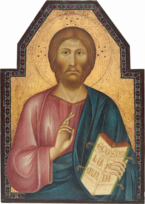Shown from the waist up, a pale-skinned man with long, honey-blond hair and beard faces us in front of a gold background in this vertical painting. The man has a long face and nose, with closed peach-colored lips, which turn slightly down at the corners. Almond-shaped, hazel-brown eyes under arched brows stare over our left shoulder. His rose-pink robe is covered by a spruce-blue mantle that drapes over the left shoulder, on our right, and wraps around the waist. The robe and mantle are trimmed with gold. His right hand, on our left, is raised with the index and middle fingers extended up. The other hand holds an open book so the pages face us. The top edge of the pages is burnt orange, and the left and right edges are moss green. The side facing us is inscribed in gold letters, “ECO SUM LUX MUNDI.” A halo incised into the gold background surrounds the man’s head, and clusters of five dots in dark red, blue, and black are placed at the top and to either side within the halo. The panel on which this is painted has a five-sided, angular arch on top that frames the man’s head. A border within the frame has a pattern of gray circles and scarlet-red diamonds against a navy-blue band. The border follows the contours of the panel but runs behind the man’s body, as if he stands in front of it. The panel is framed with dark wood.