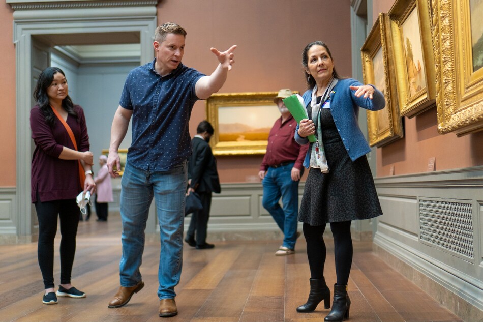Visitors look at a painting in the National Gallery of Art.