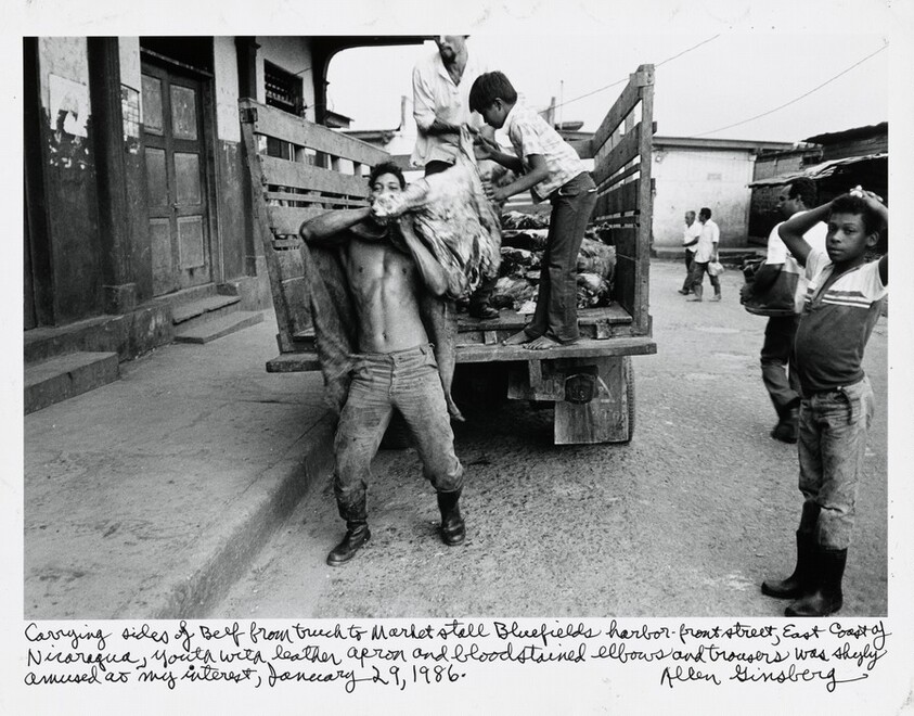 Carrying sides of Beef from truck to Market stall Bluefields harbor-front street, East Coast of Nicaragua, Youth with leather apron and bloodstained elbows and trousers was shyly amused at my interest, January 29, 1986.
