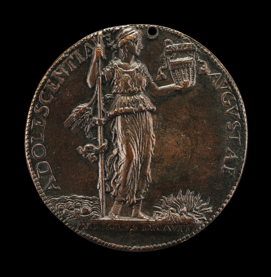 This is a photograph of an ancient coin. The coin features a relief sculpture of a figure wearing a toga and a laurel wreath, holding a musical instrument, possibly a lyre, and a staff. The design suggests influence from ancient Rome or Greece, with symbolic elements associated with mythology or leadership. Engraved text surrounds the figure, and there are intricate details such as wave-like patterns at the figure's feet and ornamental bushes. The coin has a bronze hue, indicating its metallic composition and potential age.