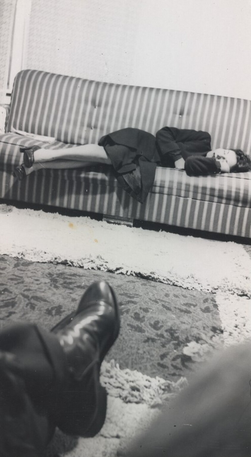 Untitled (Woman sleeping on striped couch with foot in foreground)