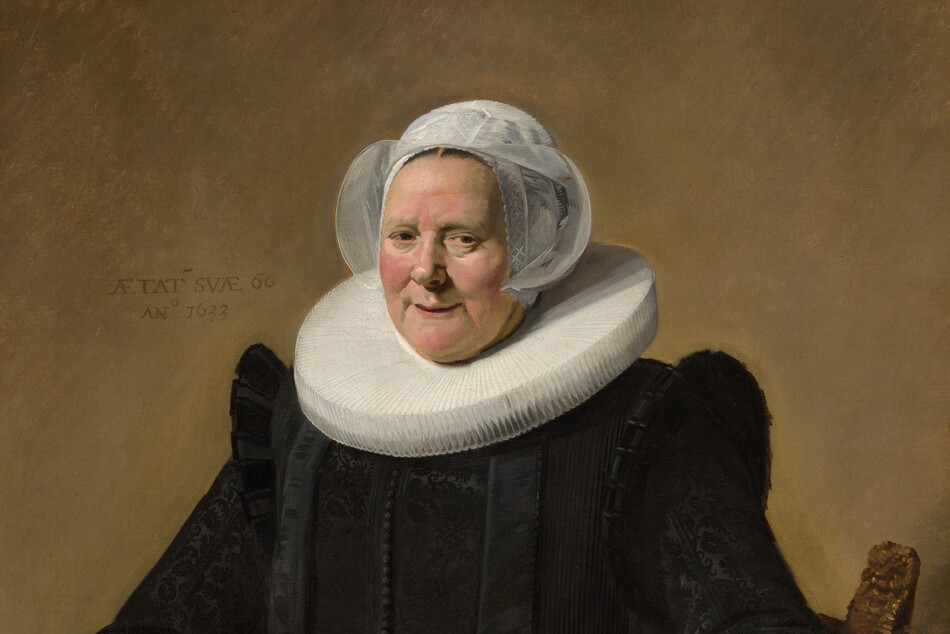 This vertical portrait painting shows a pale-skinned older woman wearing a full, long-sleeved black dress with a wide white ruff at her neck and white lace cuffs at her wrists. She sits in a curving, low-backed wood chair against a pale brown background. Her body and the chair are angled slightly to our left, and she looks directly at us. She has small eyes, pink, rounded cheeks, and a wide chin. Her lips are parted in a slight smile, and her hair is covered by a starched, sheer white cap that flares at the sides. The ruff around her neck is gathered in accordion-like, narrow figure-eight folds, and it extends flat and stiff, nearly to her shoulders. Close inspection reveals that the dress is woven with a black-on-black brocade pattern and has a line of small black buttons down the front. She holds a small brown leather book tooled with gold ornament in her right hand, on our left, and her other hand rests on the arm of the chair. She wears a gold ring on each hand. An inscription is painted to our left of her head: “AETAT SVAE 60 ANo 1633.”