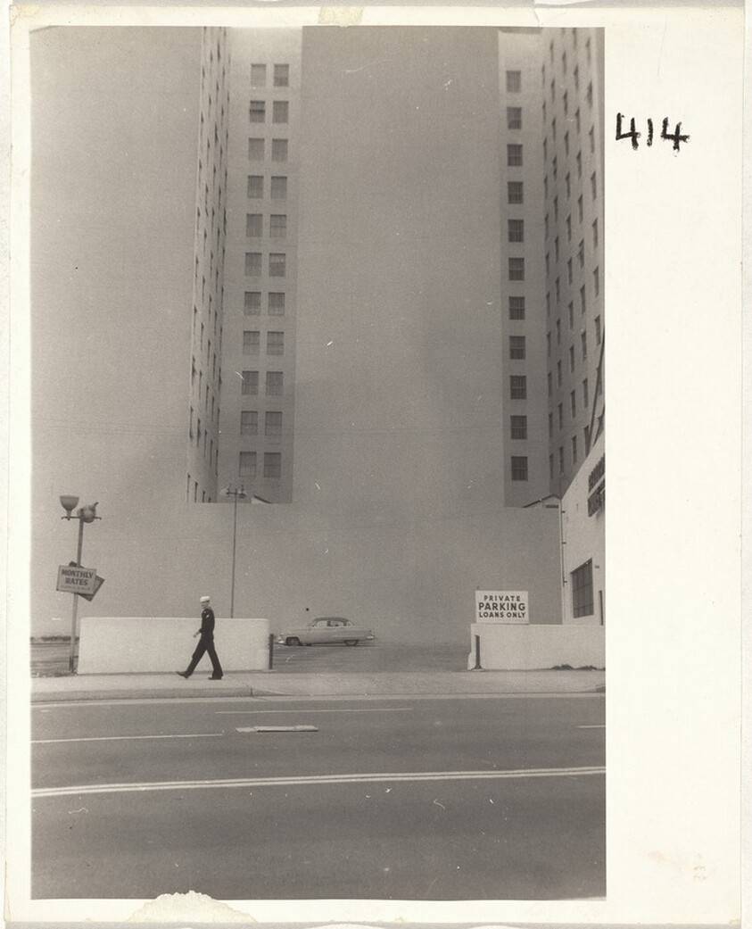 Sailor walking by parking lot--Los Angeles