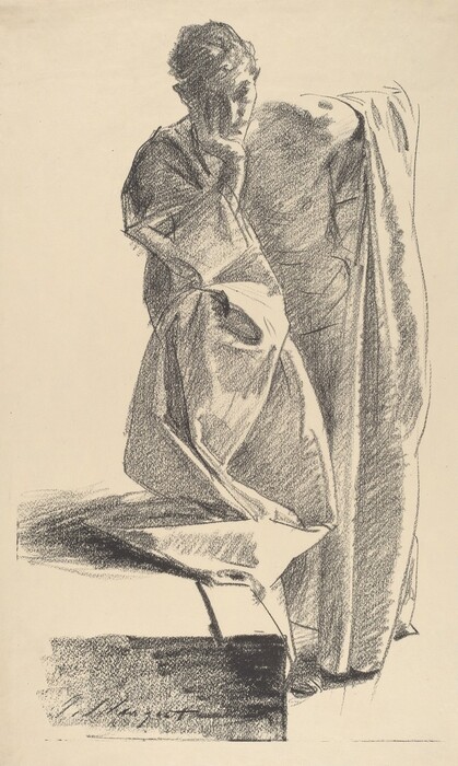 The image depicts a person in a full-body view. The individual is seated, leaning slightly forward with their left arm resting on a surface and their right arm raised to their face. The facial features appear contemplative, with shading that highlights the contours of the face. The hair is styled in loose curls or waves. They are draped in a voluminous garment that wraps around their body, with folds and shadows giving the fabric a sense of depth and weight. The person holds nothing in their hands and wears no visible jewelry. The background is plain paper.