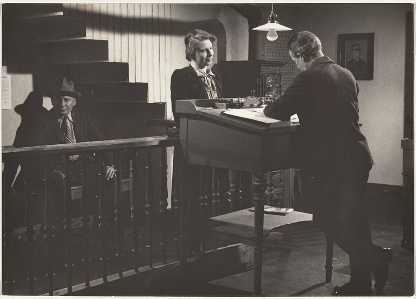 Woman before man at desk--Filming