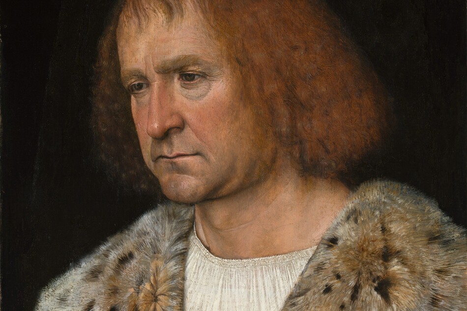 Shown from the chest up, a clean-shaven, pale-skinned man holds one hand to his chest and rests the other on a rug-covered ledge with the other in this vertical portrait painting. The man’s body is angled to our left, and he looks down in that direction with dark eyes under thick brows. Crow’s feet crinkle at the corners of his eyes, and there are dark hollows underneath. Soft jowls hang to create a slight double chin. His thin lips are set in a line over a wide, round chin, which is darkened with a five o’clock shadow. He has chin-length, reddish-blond hair, and straight, wispy bangs sweep loosely across his high forehead. He wears a white chemise under a gold, brocade garment, which is mostly hidden by a slate-blue cloak. The cloak is lined with spotted fur, which is turned over to create a wide collar across his shoulders. The sleeve on his left arm, to our right and closer to us, splits over a dusky-pink sleeve. Two gold buttons on the cloak there are decorated with thistle plants and blossoms. The fingers of his right hand, to our left, are gathered like a closed rose bud at his chest. He wears a gold ring on the index finger of the other hand, which rests on the end of the gray stone ledge so his fingertips brush the tapestry draped there. The man is lit from our left against a black background.