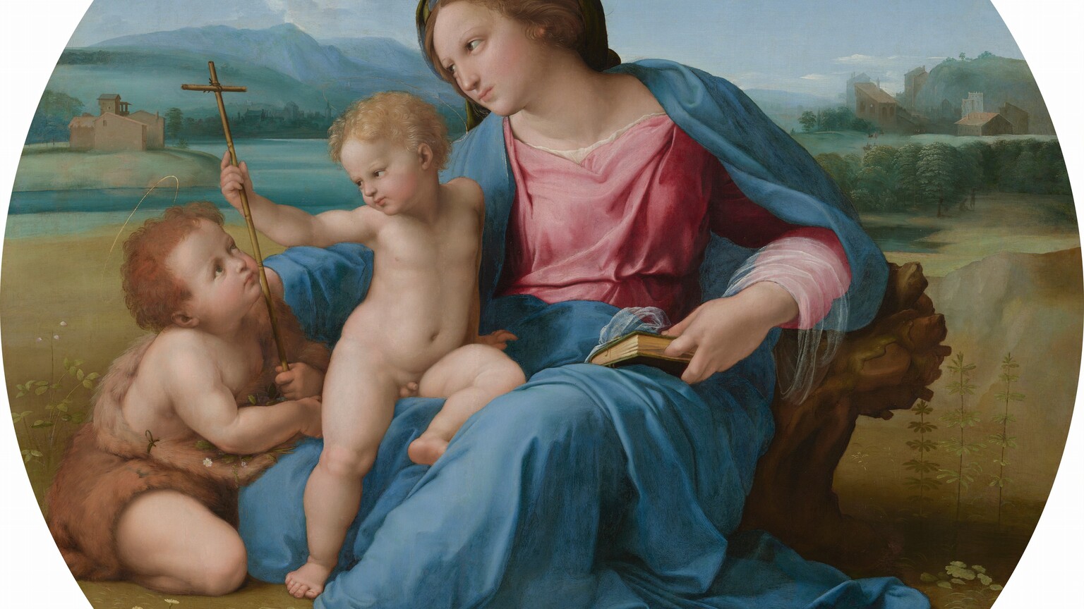 A woman and two children, all with pale skin and flushed cheeks, sit together in a landscape in this round painting. The woman takes up most of the composition as she sits with her right leg, to our left, tucked under her body. Her other leg, on our right, is bent so the foot rests on the ground, and that knee angles up and out to the side. She wears a rose-pink dress under a topaz-blue robe, and a finger between the pages of a closed book holds her place. Her brown hair is twisted away from her face. She has delicate features and her pink lips are closed. She looks and leans to our left around a nude young boy who half-sits and half-stands against her bent leg. The boy has blond hair and pudgy, toddler-like cheeks and body. The boy reaches his right hand, on our left, to grasp the tall, thin cross held by the second young boy, who sits on the ground next to the pair. This second boy has darker brown hair and wears a garment resembling animal fur. The boy kneels facing the woman and looks up at her and the blond boy. The trio sits on a flat, grassy area in front of a body of water painted light turquoise. Mountains in the deep distance are pale azure blue beneath a nearly clear blue sky.