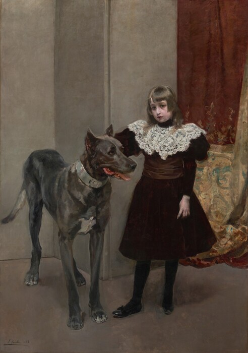 This painting shows a young girl standing beside a large dog. The girl has a fair complexion and straight brown hair that falls on her shoulders. She is wearing a dark burgundy dress with a white lace collar, black stockings, and shoes. She looks directly at us. The dog to the left reaches almost to her shoulder and has a light gray coat. Its mouth is slightly open, revealing a pink tongue and the tips of white teeth. The background is mostly plain gray walls, but on the right side there is elegant drapery in shades of deep red and gold with intricate teal designs.