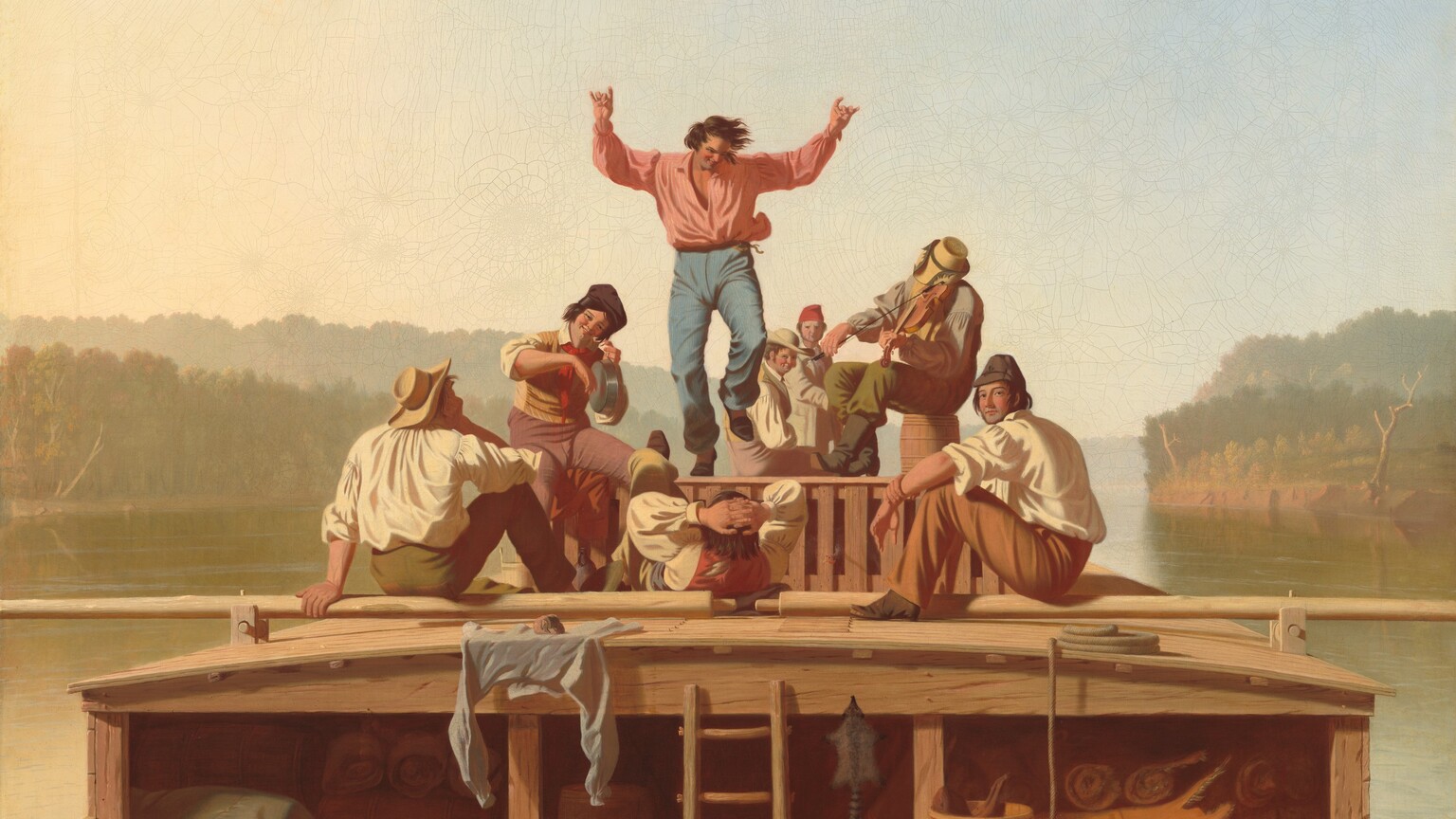 A flatboat with eight light-skinned men floats toward us down a wide river in this horizontal painting. The boat nearly spans the width of the composition and has low sides and a shallowly arched, low cabin upon which the men gather. At the center, a man with dark hair and wearing light blue trousers and a pink shirt dances with one foot and both arms raised. To our right a seated musician plays a fiddle, and to our left a smiling man holds up a metal pot and strikes the flat bottom with the back of his fingers. The remaining men sit or recline around the musicians and dancing man, some looking toward the dancer and two looking out at us. Bedrolls and animal skins are stored in the cabin below. The olive-green surface of the river is streaked with pale blue. The horizon line comes about a third of the way up the composition. The trees and riverbanks in the distance are hazy beneath a watery blue sky.