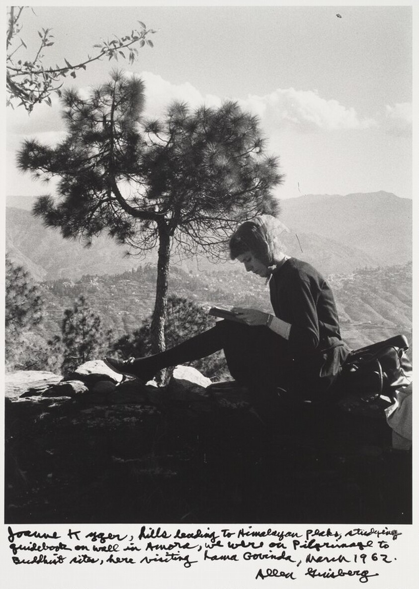 Joanne Kyger, hills leading to Himalayan flats, studying guidebook on wall in Aurora, we were on Pilgrimage to Buddhist sites, here visiting Lama Govinda, March 1962.