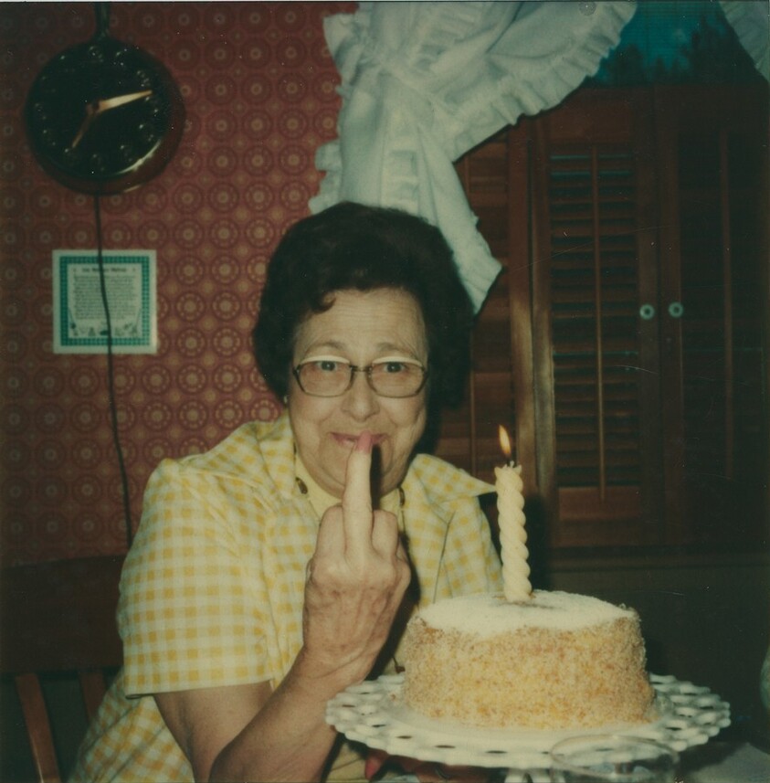 Untitled (Woman giving the finger with birthday cake)