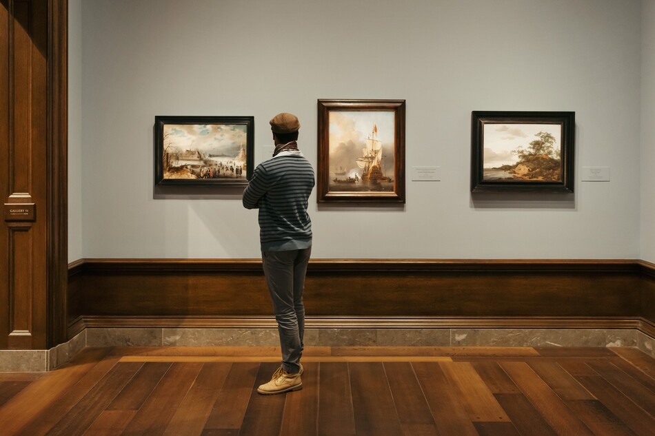 A visitor looking at a painting in the National Gallery of Art.