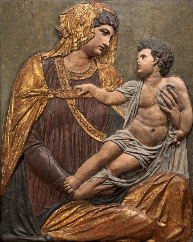 A woman and baby are modeled with papier mâché and stucco in low relief and then painted and gilded in this vertical panel. The woman and child both have peachy, pale skin and dark brown, wavy hair. To the left, the woman looks in profile at the baby she holds to our right. The woman has large, dark eyes, a delicate nose, and her lips are closed. Her head is covered by gold fabric, which falls over her shoulders. A burgundy-red dress is edged in gold under a navy-blue cloak. More gold cloth covers her lap along the bottom edge of the panel. She cradles the baby in both hands. One of the child’s shoulders and his hips are draped with pale gray fabric. He has pudgy arms and legs but a slightly muscular torso. He also has delicate features in a round, pudgy face, and he looks up at the woman. One hand grips the gray fabric and the other hooks onto a strap holding the woman’s gold cloak closed. The background is a muted greenish-brown.