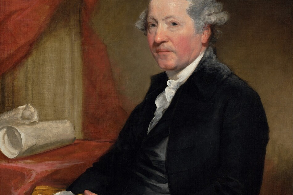 This is a portrait of a man shown from the waist up. He is seated, facing slightly to the left but looking directly at the viewer. The man has light gray hair styled back from his face, with curls visible at the sides. His skin is fair with slightly pink cheeks. He is wearing a formal outfit: a dark jacket with a white high-collared shirt underneath with ruffled edges. He holds a small object, possibly a box, in his hands which are placed in his lap. There is a red cloth or curtain behind him, with rolls of parchment or cloth on a table nearby. The wall behind him is a muted green.