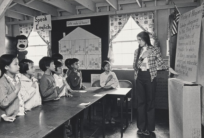 Teacher leads class of UN refugee children in Pledge of Allegiance, at Fort Indiantown Gap, PA