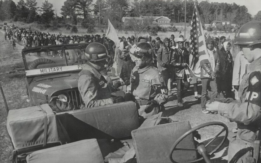Title from caption on object: “Soldiers Kept alongside Marchers as Demonstrators Walked on Highway 80”