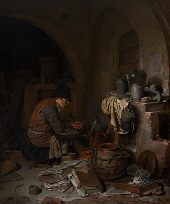 A light-skinned man sitting near an oven is surrounded by papers and vessels, all within a shadowy room in this vertical painting. The scene is dominated by chocolate and clay brown, black, slate blue, and shades of gray. The man sits facing our right in profile near the center of the painting. He wears a tall black cap that shadows his eyes and a rust-brown sleeveless garment like a vest over dark, steel-gray, long sleeves. Cream-white fabric tied around his waist could be an apron, and more white fabric drapes over his knees. Brown hair is visible behind his ear, he has a mustache, and his lips are parted as he looks down toward the instruments in front of him. He is hunched over, the elbow closer to us on what might be a flattened bellows, and he holds tongs in his left hand. The vessel in front of him could be made from pewter or glass, and it has a high, curved top and a long spout angled downward. Other pots and a red cloth are jumbled with large, leather-covered folios like thick folders of papers on the floor close to us. More papers, pots, and containers sit on a wide ledge over the open fireplace or oven to our right. A piece of parchment-white cloth hangs down the front of the oven next to a leather knapsack that hangs from the mantle. The top zone of the painting is deep in shadow but there seems to be an arched window or door covered with a wooden shutter to our right, behind the oven. A piece of paper affixed to the wall near the opening shows a vessel like the long-spouted vessel in front of the man. A shallow wooden box near the lower right corner seems to be filled with crumpled paper or cloth. The artist signed and dated the front face of the box with light letters: “C. Bega Ao. 1663.”