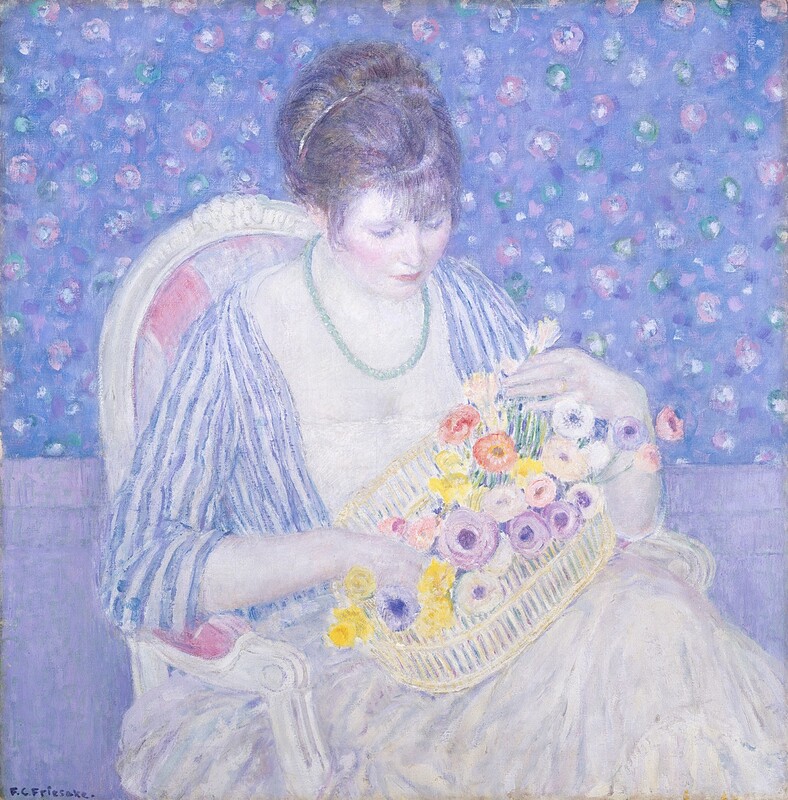 Shown from the lap up, a woman looks down at a basket of flowers held on her lap in this square painting. The woman’s body is angled to our right, and her head tips down in that direction. The woman’s skin is pale, nearly white-colored and shaded with icy blue except for her faintly flushed cheeks and pink lips. Her brown hair, which is pulled up and back, and her bangs are shaded with violet purple. A necklace of pale turquoise-green beads hangs around her neck. The dress has a white bodice with a straight neckline and a full pearl-white skirt, which are also shaded with pale blue and purple. Her jacket has three-quarter length sleeves and is striped with indigo blue and white. The oval basket is tipped up to our right, suggesting that one knee is crossed over the other. The woman’s right hand, to our left, nestles among the flowers, and she holds the stem of a white flower with her other hand. She wears a gold band on the ring finger of that hand. Her armchair has a wood frame painted white with a rounded back, which is upholstered in mauve-pink and white stripes. The floor is lilac purple, and the wall above is patterned with purplish-pink and white flowers and green leaves against an amethyst-purple background. The entire painting is created with blended strokes, giving it a soft look, and has a frosty blue and pale purple cast. The artist signed the work in the lower left corner, “F.C. Frieseke.”
