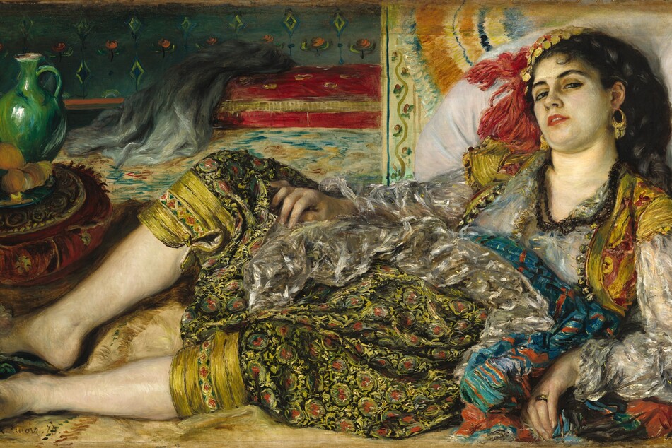 A woman wearing a sheer white blouse, short red and gold vest, and full-legged, patterned pants cinched below the knee lies back and looks at us with hooded eyes in this horizontal painting. Her shoulders lean back against an oversized white pillow, up along the right edge of the composition. Her body tips toward us, and her knees are bent so her feet are together in the lower left corner. Her right arm rests along the side of her body, and she props herself up with her other arm. That hand has a gold band on the ring finger. Her light skin is tinged with green on her face. Her head rolls slightly away from us so she looks down her cheeks at us with slitted, dark eyes through heavily lined lids. She has dark brows, and her rose-red lips are parted. The angle of her head creates a slight double chin. Gold hoops with dangling fringe or chains hang from her ears, and she wears three strands of dark beads around her neck. Her black hair is plaited in a thick braid that comes down over her left shoulder, closer to us. A cap made of gold-colored disks and red fringe sits on the far side of her head. The woman’s clothing is more loosely painted. We may see her breasts and pink nipples through her sheer, silver-gray tunic, which has long, voluminous sleeves. The short, bolero-style vest is strawberry red and gold, with narrow cap sleeves. A sea-blue sash around her waist is striped with overlapping burnt-orange and black lines. Her pants have flaring legs gathered with a button just below her knees. The pattern is of sage-green circles with swipes of rust-red in the center, suggesting flowers and vines against a black background. Her knees are spread open so her feet can barely be contained within the composition. Her teal-green slip-on shoes have the suggestion of flowers painted with dabs of yellow, black, and red, and a pompom atop each toe box. A red and gold cushion sits just beyond her feet. On it is a tray of oranges and an emerald-green jug. The pillow the woman leans on is propped against a short section of wall or piece of furniture painted with a border of roses. The room opens up beyond this, and has a turquoise and brown rug leading back to a cranberry-red sofa, on which a gray piece of fabric has been draped. The wall above is patterned with yellow and green diamonds and pink flowers against a laurel-green background. The artist signed the lower left, “A. Renoir. 70.”